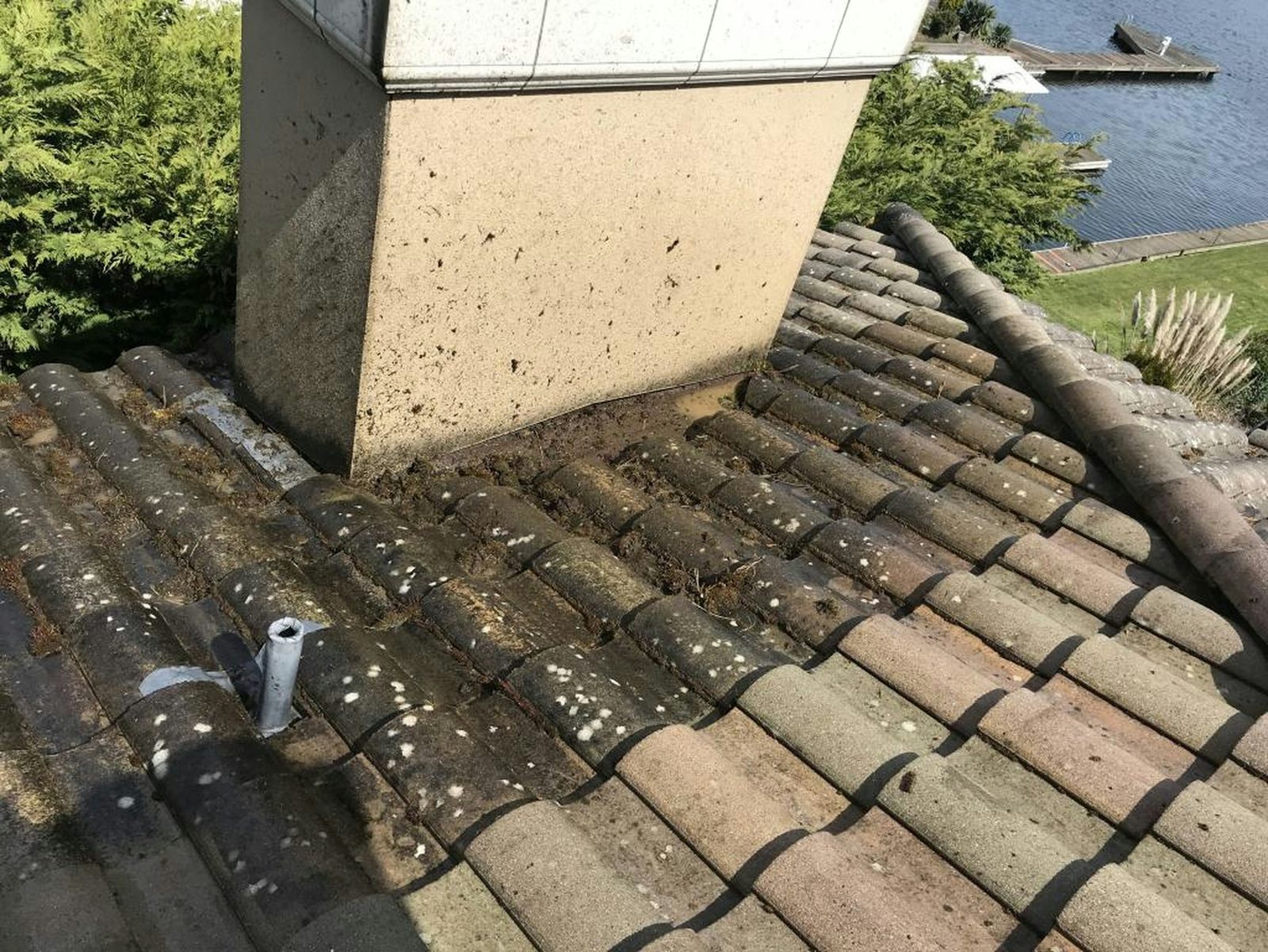 Chimney base and vent pipe rising through a tile roof
